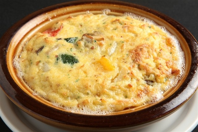 卵と野菜を混ぜたふんわりとした焼き料理。チーズの溶けた表面がこんがりと焼けている